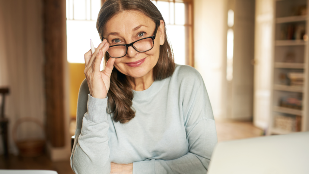 Mulher segurando os óculos e sorrindo, para falar sobre os cuidados para quem tem glaucoma