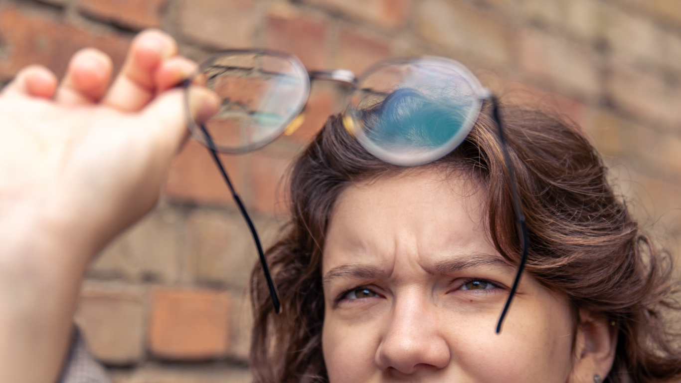 Mulher com sintomas visuais, tentando ver através de óculos