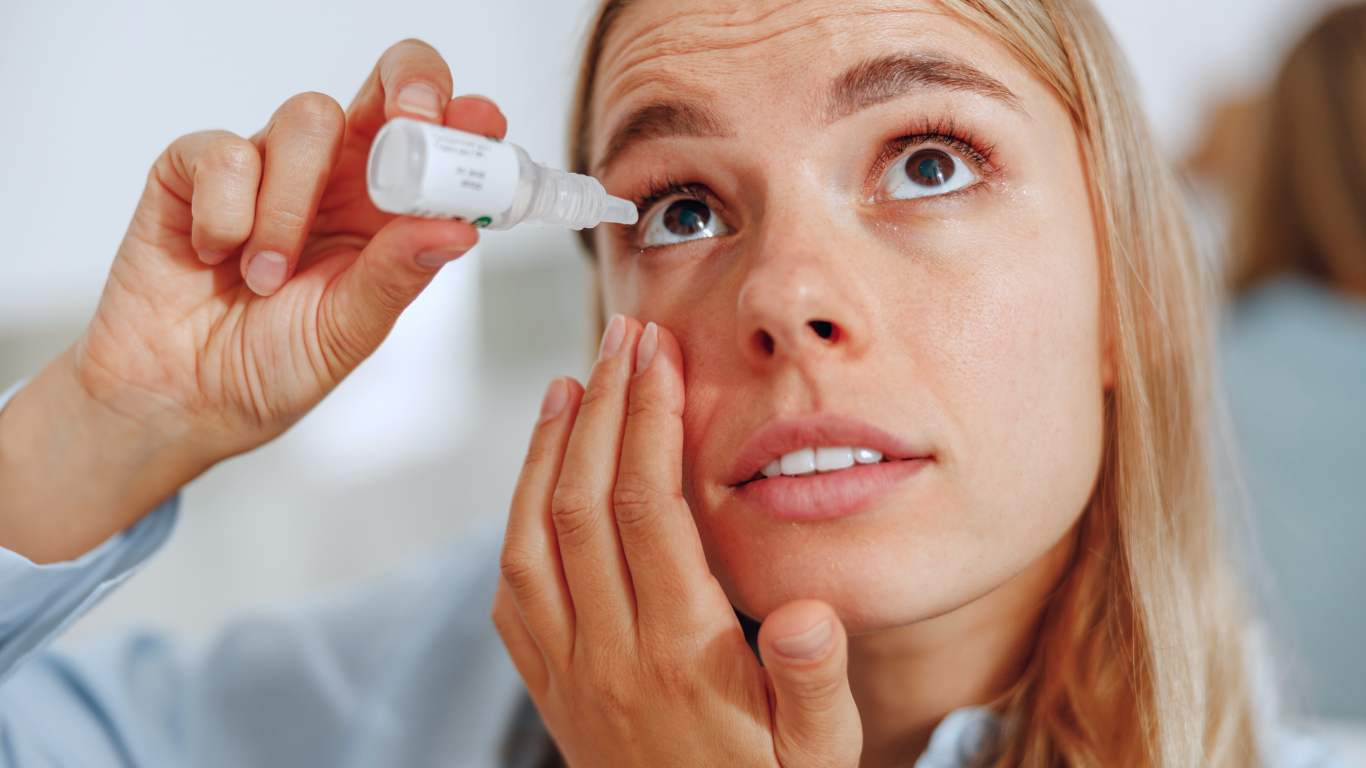 Mulher colocando colírio em olho seco